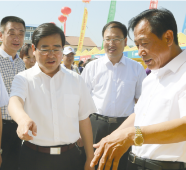 沁縣縣委書記盧展明、政府副縣長魏瑛在首屆太行山名優特新農產品展銷會沁州黃集團展位上參觀指導